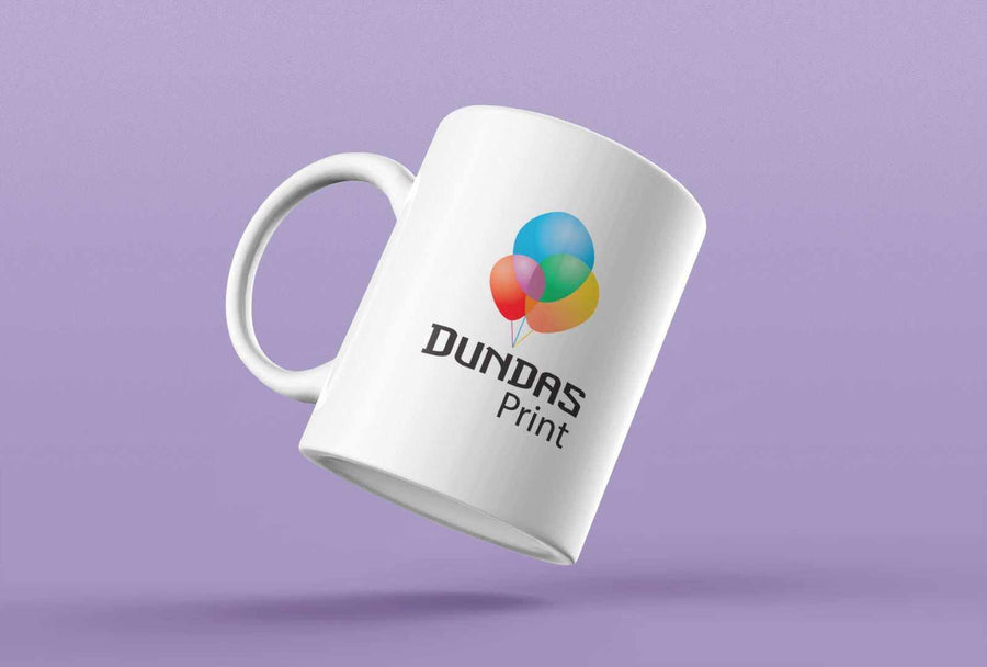 White custom printed mug with colorful balloon logo and Dundas Print text on purple background