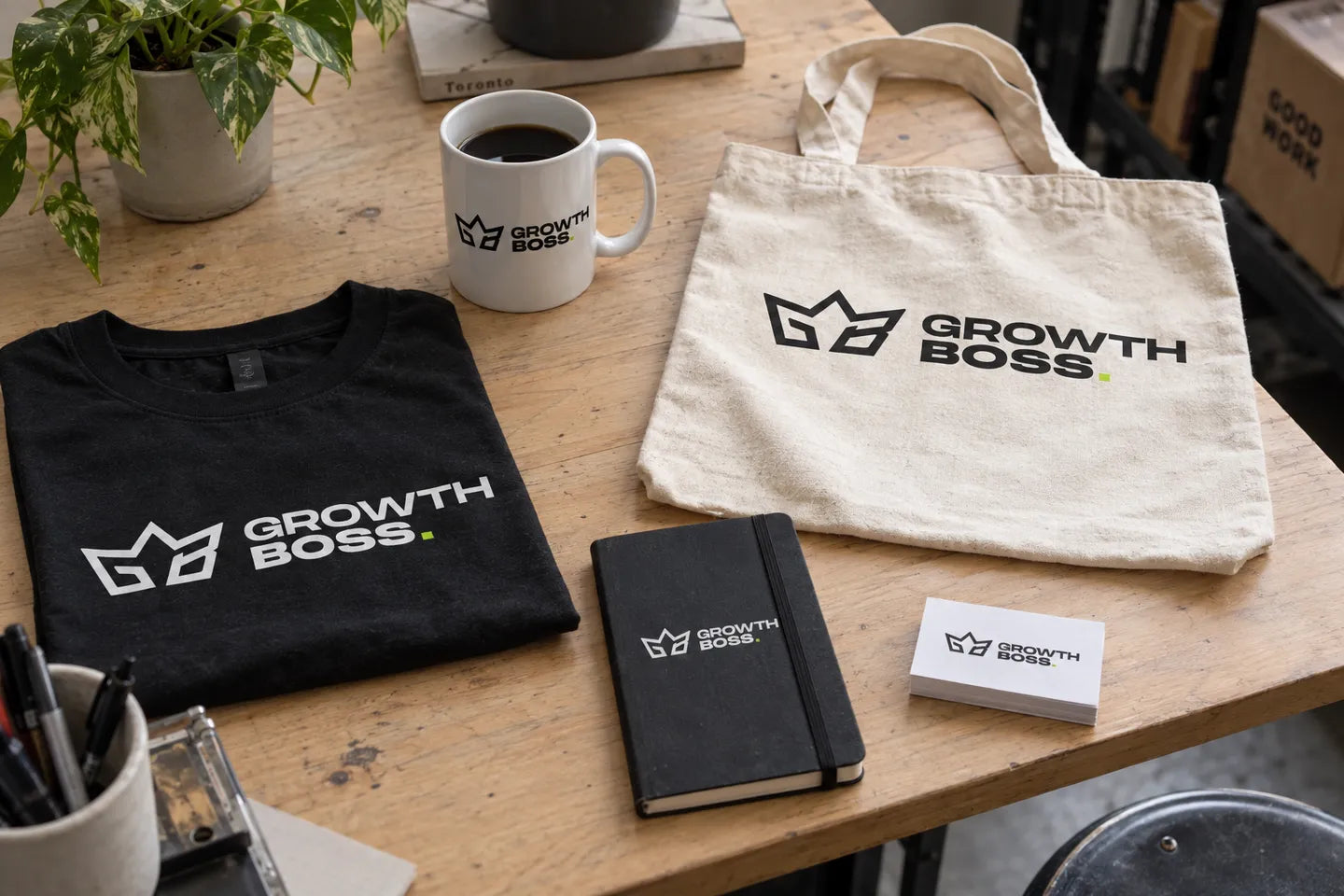 A mug, t-shirt, tote bag, notebook and cards printed with the Growth Boss logo
